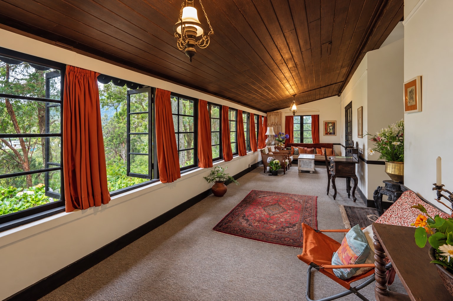 Selwood’s sunlit veranda, with warm timber ceilings and open windows onto the garden